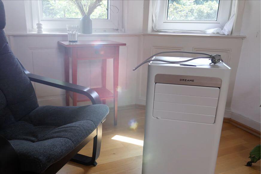 Dreame P-Wind 10 Klimaanlage mit Rollen auf dem Boden im Wohnzimmer am Fenster